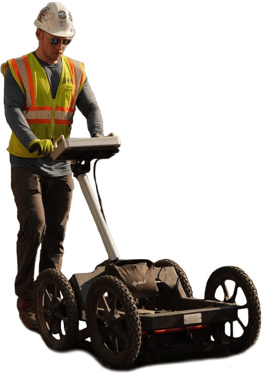 Construction worker operating a ground penetrating radar cart on a work site